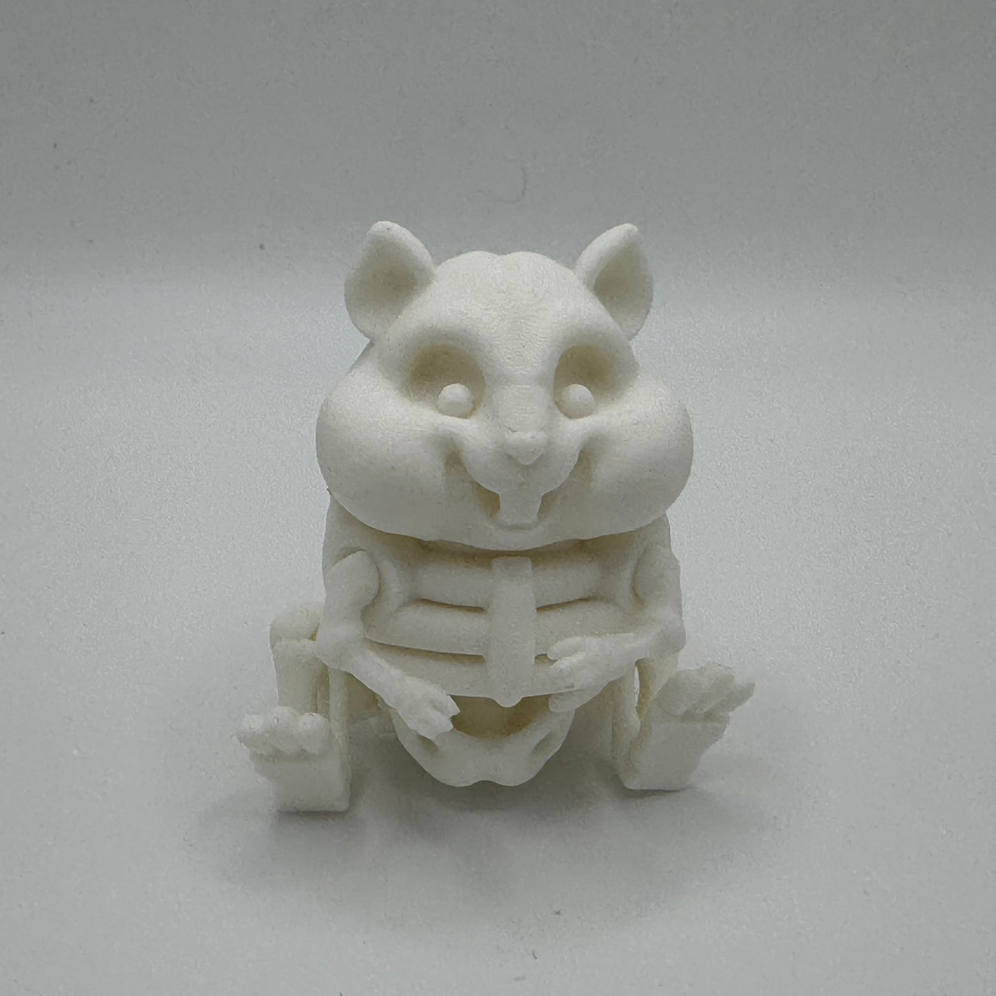 White 3D-printed hamster skeleton figurine on a gray background