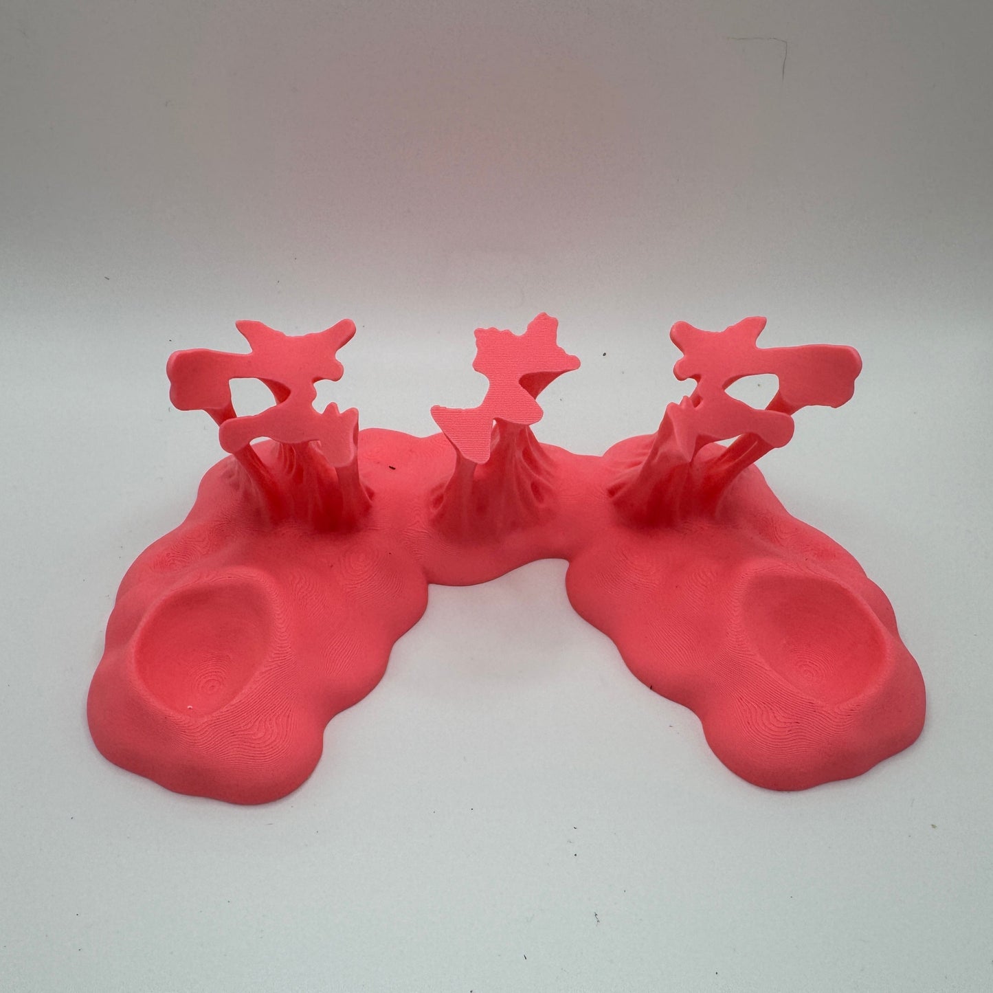 a pink plastic goo stand against a white background