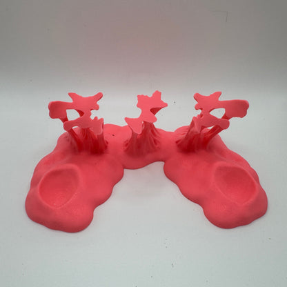 a pink plastic goo stand against a white background