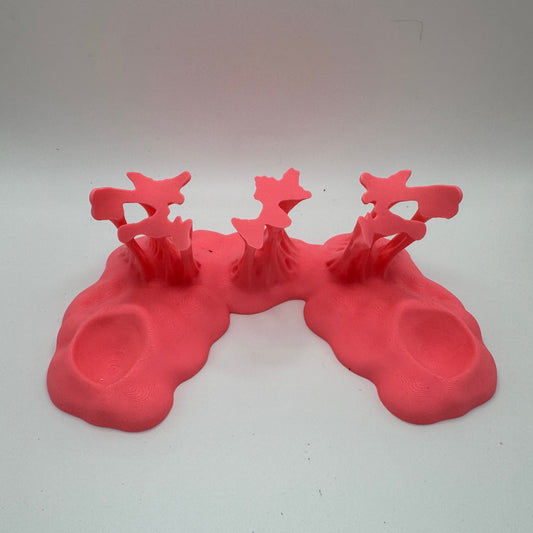 a pink plastic goo stand against a white background